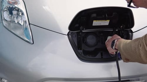Electric Car Being Plugged In for Charging