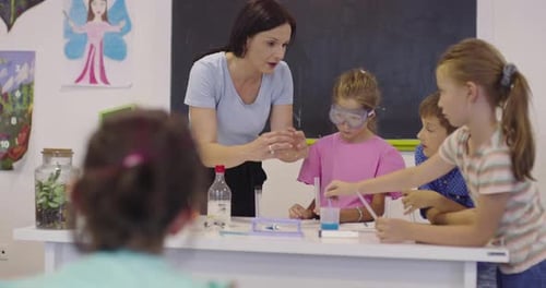 Elementary School Science Classroom Enthusiastic Teacher Explains Chemistry to Diverse Group of
