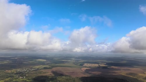 Aerial View From Airplane Window at High Altitude of Earth Covered with White Puffy Cumulus Clouds