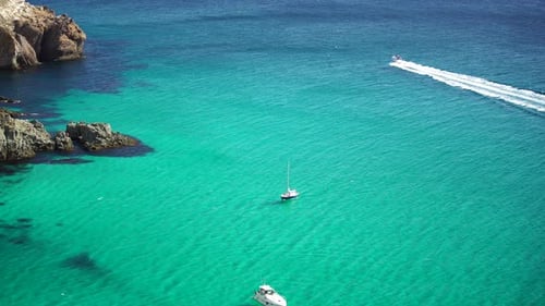 Boats and Yachts in the Rocky Bay with Crystal Clear Azure Sea on a Sunny Day