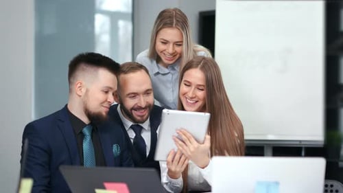 Team Looks at Tablet in Modern Office