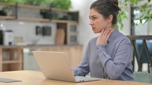 Woman Rubbing Stiff Neck While Typing at Laptop