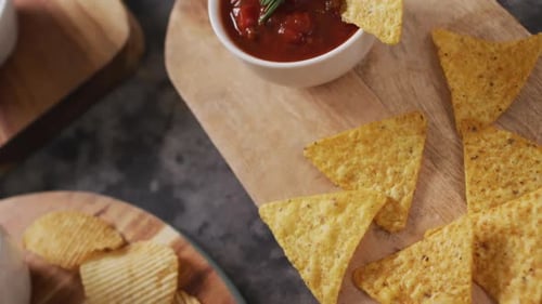 Vista de cerca de una variedad de patatas fritas y salsas en bandejas de madera sobre superficie negra