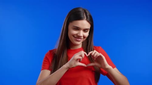 Smiling Woman Makes Heart Shape With Hands