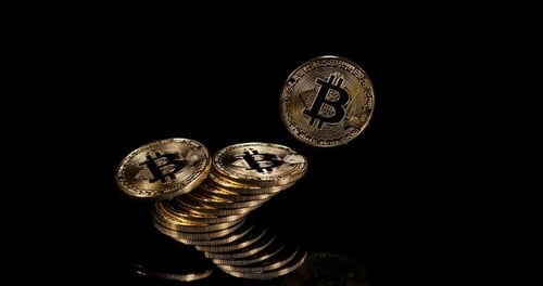 Golden Bitcoin Coins Falling on Black Background