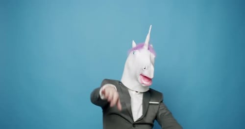 Glücklicher Kerl in grauen Anzügen Er hat Spaß mit Einhornmaske