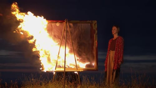 Woman Standing by Burning Painting on Easel at Night