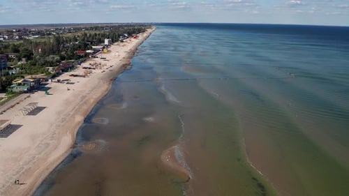 Beautiful flight in summer over the beach. People are resting near the sea.