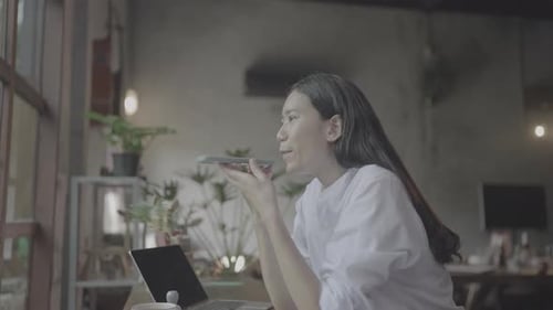 Young Woman Leaving Voice Message on Mobile Phone