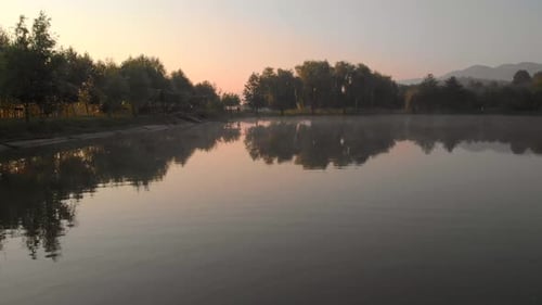 Pink Sky at Sunrise and Mist on the Lake and Alpine Village