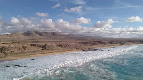 A Body of Water with a Mountain and Clouds in the Background