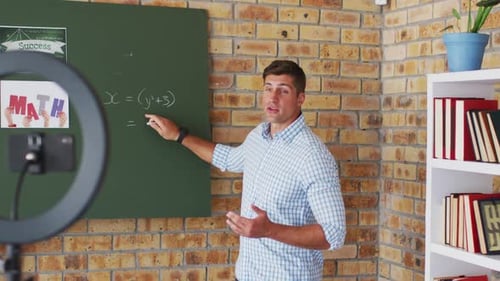 Man Teaching Math Lesson in Front of Chalkboard