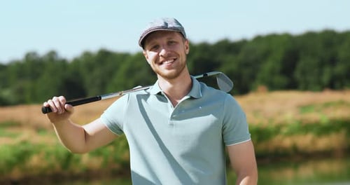 Smiling Man Holds Golf Club On Green Course