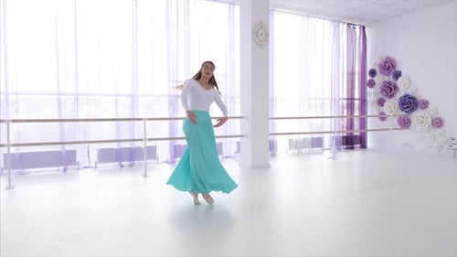Graceful Young Woman Dancing Ballet in Bright Studio