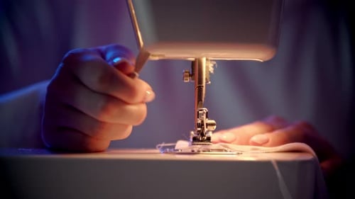 Woman using a sewing machine in a studio