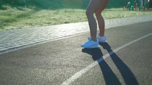 Woman Warming Up Squatting at Stadium