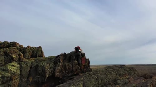 View of a Human Climbing to the Top of a Mountain