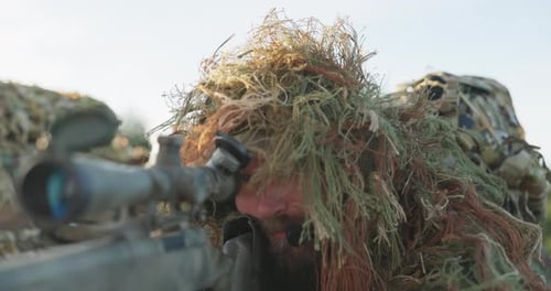 Soldier Lies on the Ground and Patrols the Area From Concealment Opens the Flap of Binoculars Looks