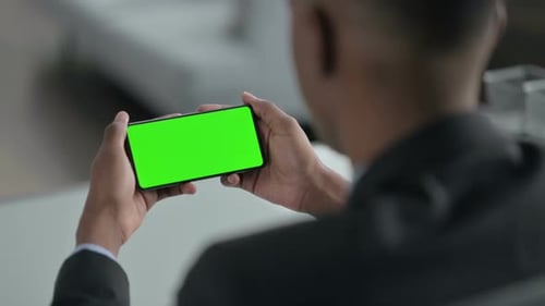 Rear View of African Businessman Looking at Smartphone with Chroma Screen