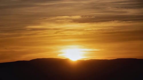 Scenic Golden Sunrise Over Mountain Silhouette