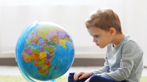 Young Boy Looking at World Globe