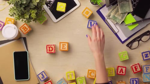 Woman Hand Arranging Wooden Cubes with Word DEVICE Top View