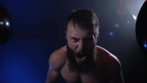 Portrait du boxeur sportif agressif et transpirant regardant la caméra et criant dans un centre de remise en forme