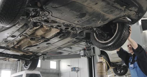 Mechanic Draining Old Brake Fluid From A System During The Service. Middle Shot