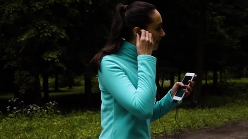 Happy Sporty Woman in Headphones Outdoors in Parkon Asphalt Road Running.