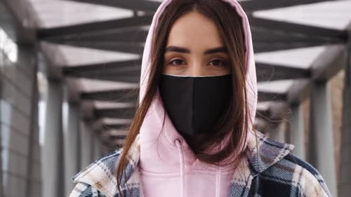 Pandemic, face of a young woman wearing protective mask inside building. covid concept health and sa