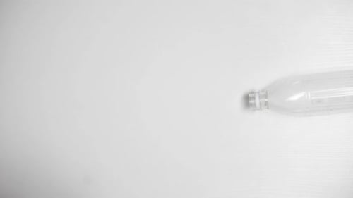 Empty Plastic Bottle Rotating on White Surface