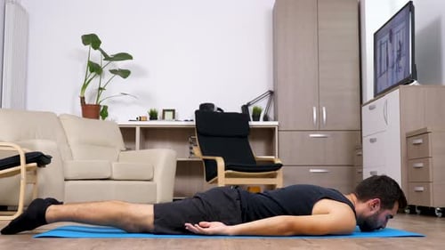 Man Doing Back Extensions on Yoga Mat Indoors