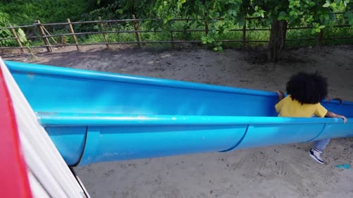 4K Little African girl sliding and playing at playground in the park