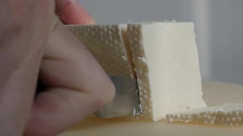 White cow milk cheese cutting with knife 4K footage
