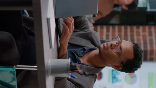 Man Smiling at Desk Working on Laptop