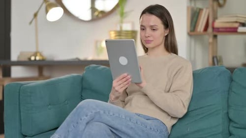 Young Woman Relaxing at Home Using Tablet