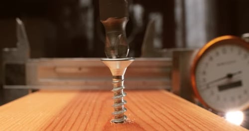 Closeup es un taladro eléctrico que atornilla un tornillo autorroscante en una barra de madera