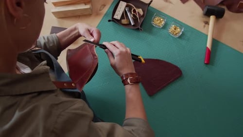 Woman Trimming Leather with Blade at Desk
