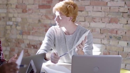 Team Discussing Documents in Urban Workplace Setting