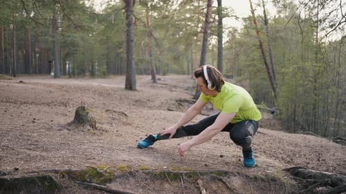 Runner in Yellow Tshirt Warms Up Before Running in Forest