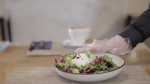 Fresh Salad Being Placed on Table