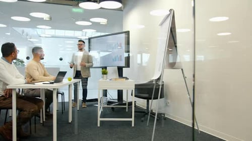Male Manager Making Financial Report Using Interactive Board for Presentation in Office