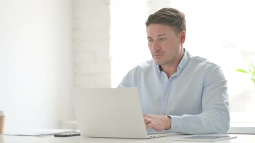 Man having Neck Pain while using Laptop in Office