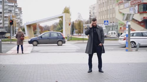 Businessman with mobile phone outdoors. Young businessman talking on mobile phone on street