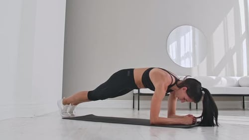 Athletic Beautiful Woman Does Running Plank As Part of Her Cross Fitness Bodybuilding Gym Training
