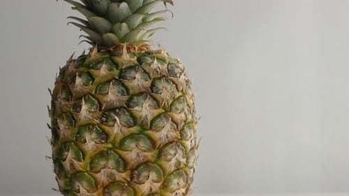Primer plano de una exótica piña sobre un blanco con inclinación lenta, 4K, 2160p, 30 fps, imágenes UltraHD - Tilting on Ananas