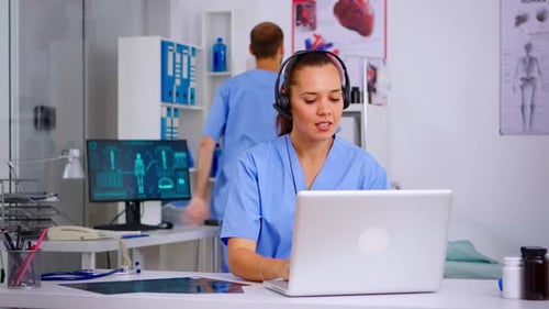 Healthcare Professional Working at Desk on Laptop