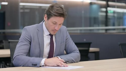 Adult Man Signing Business Contract in Office