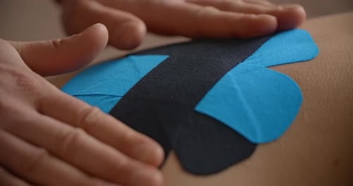Close Up Shot Physiotherapist Sticks Kinesio Tapes to the Back of Patient Kinesiology Taping
