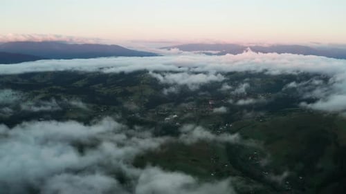 Luftaufnahme des nebligen Sonnenaufgangs in den Bergen